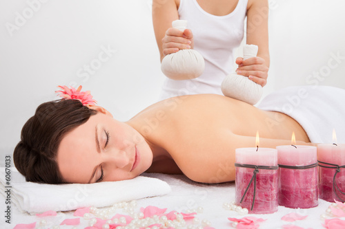 Photo: Woman Getting Herbal Compress Ball Therapy Woman Getting Herbal Compress Ball Therapy