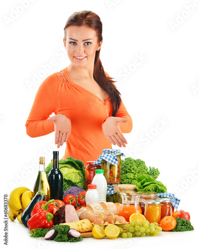 Photo: Young woman with assorted grocery products isolated on white Young woman with assorted grocery products isolated on white