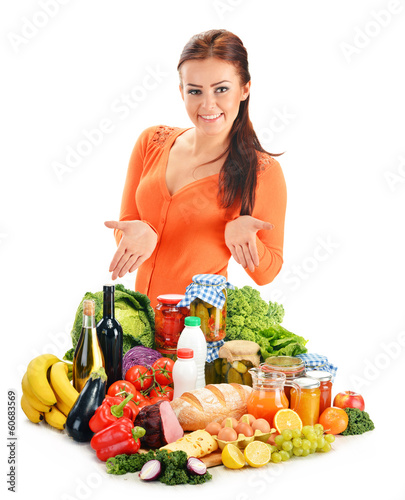 Photo: Young woman with assorted grocery products isolated on white Young woman with assorted grocery products isolated on white