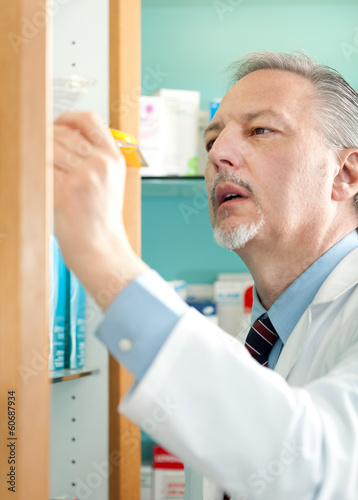 Photo: Portrait of a pharmacist searching for a product Portrait of a pharmacist searching for a product