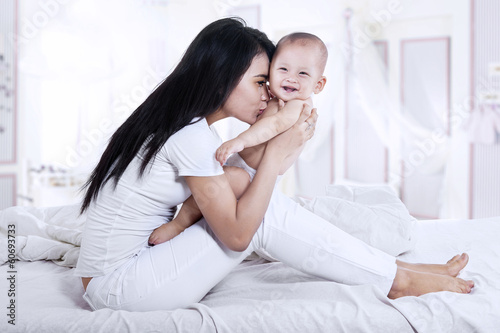 Photo: Attractive mother kissed her baby Attractive mother kissed her baby