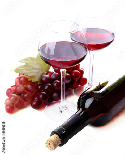 Photo: Wineglasses with red wine, grape and bottle isolated on white Wineglasses with red wine, grape and bottle isolated on white
