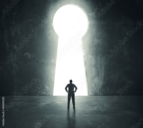 Photo: Businessman looking through key hole Businessman looking through key hole