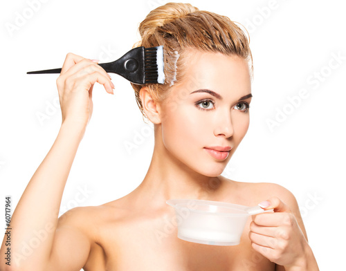 Photo: Beautiful young woman dyes her hair Beautiful young woman dyes her hair