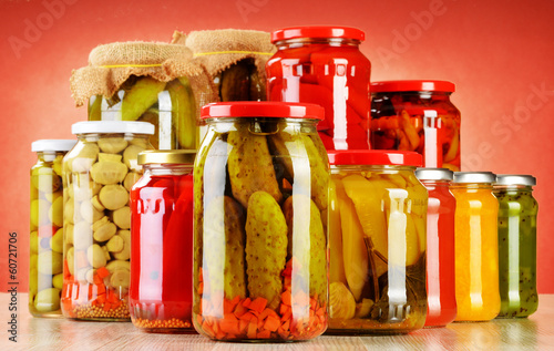 Photo: Composition with jars of pickled vegetables. Marinated food Composition with jars of pickled vegetables. Marinated food