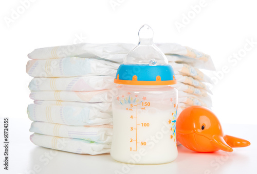 Photo: Child stack of diapers and baby feeding bottle with milk Child stack of diapers and baby feeding bottle with milk