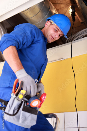 Photo: Man repairing complected ventilation system Man repairing complected ventilation system