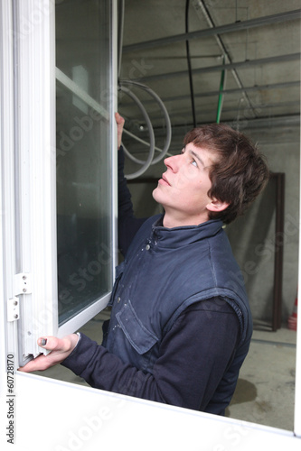 Photo: Man hanging a window Man hanging a window