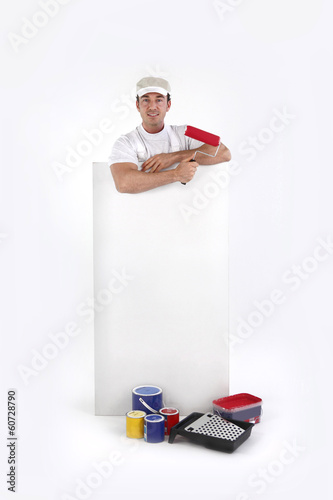 Photo: Decorator posing by a poster Decorator posing by a poster