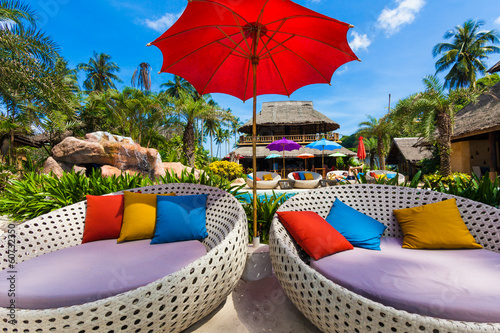 Photo: Sun umbrellas and beach chairs on tropical coast Sun umbrellas and beach chairs on tropical coast