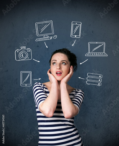 Photo: Young woman thinking with drawn gadgets around her head Young woman thinking with drawn gadgets around her head
