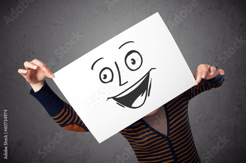 Photo: Woman holding a cardboard with smiley face on it in front of her Woman holding a cardboard with smiley face on it in front of her