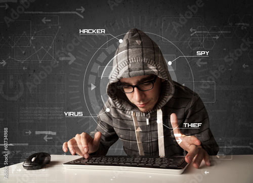 Photo: Young hacker in futuristic enviroment hacking personal informati Young hacker in futuristic enviroment hacking personal informati