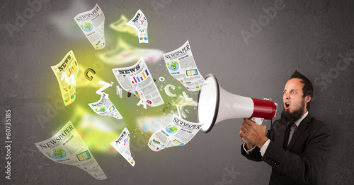 Photo: Guy yelling into loudspeaker and newspapers fly out Guy yelling into loudspeaker and newspapers fly out