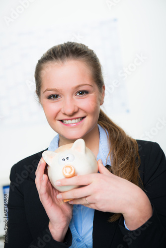 Photo: hübsche junge frau mit sparschwein hübsche junge frau mit sparschwein