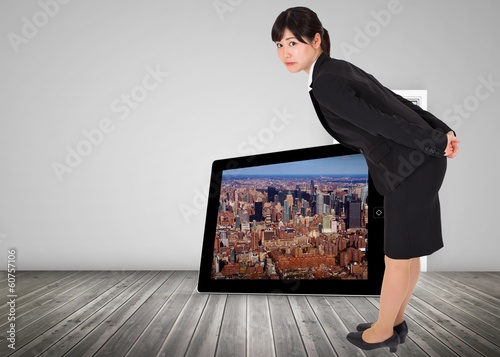 Photo: Composite image of serious businesswoman bending Composite image of serious businesswoman bending