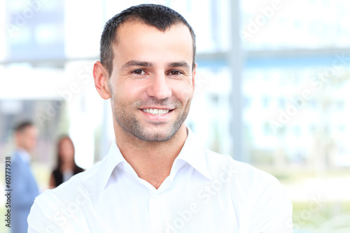 Photo: Happy smart business man with team mates discussing Happy smart business man with team mates discussing