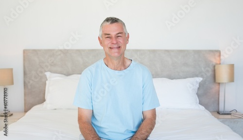 Photo: Senior man sitting on bed Senior man sitting on bed