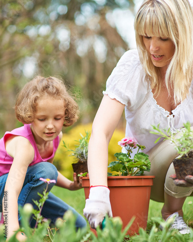 Photo: Mutter und Kind gärtnern im Garten im Sommer Mutter und Kind gärtnern im Garten im Sommer
