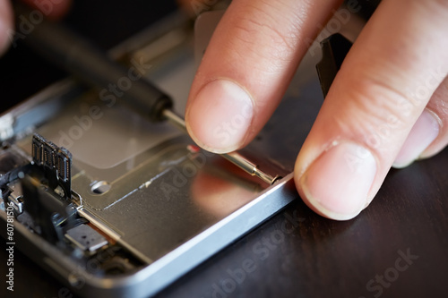 Photo: Hands fixing smartphone close-up Hands fixing smartphone close-up