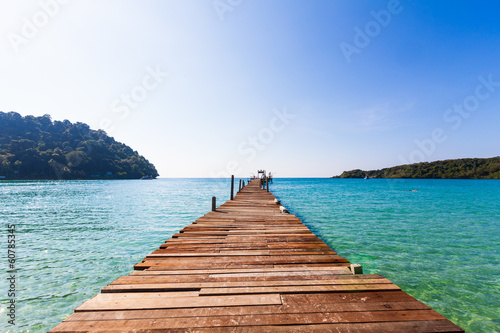 Photo: Wooden pathway. Tropical Resort. boardwalk on beach Wooden pathway. Tropical Resort. boardwalk on beach