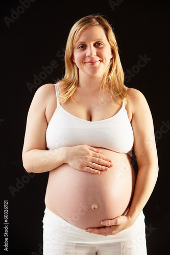 Photo: Portrait Of Pregnant Woman Wearing White On Black Background Portrait Of Pregnant Woman Wearing White On Black Background