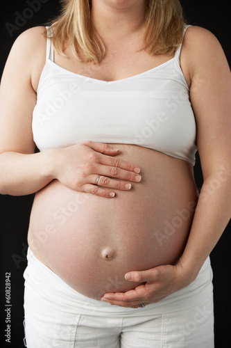Photo: Close Up Portrait Of 9 months Pregnant Woman On Black Background Close Up Portrait Of 9 months Pregnant Woman On Black Background