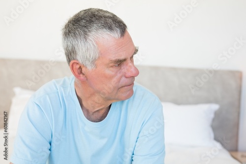 Photo: Senior man looking away on bed Senior man looking away on bed