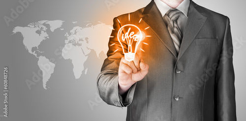 Photo: Business man touching light of idea Business man touching light of idea