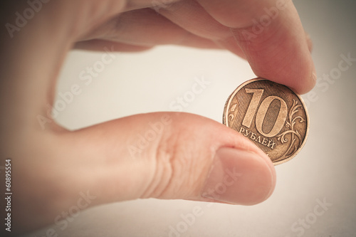 Photo: Coin in hand - ten rubles. Color toned image. Coin in hand - ten rubles. Color toned image.