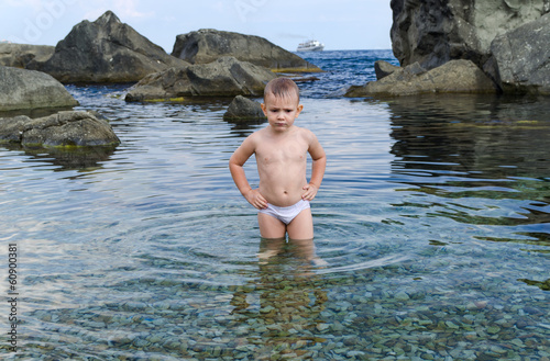 Photo: Small boy paddling in a tidal pool at the seaside Small boy paddling in a tidal pool at the seaside
