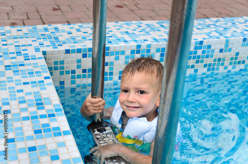 Photo: Cute little boy enjoying a swim in a pool Cute little boy enjoying a swim in a pool