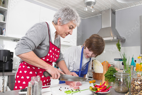Photo: Familie: Enkel mit der Großmutter in der Küche beim Kochen Familie: Enkel mit der Großmutter in der Küche beim Kochen