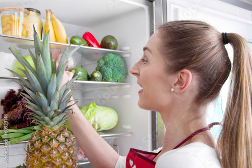 Photo: Frau legt Wert auf gesunde Ernährung - vor dem Kühlschrank Frau legt Wert auf gesunde Ernährung - vor dem Kühlschrank
