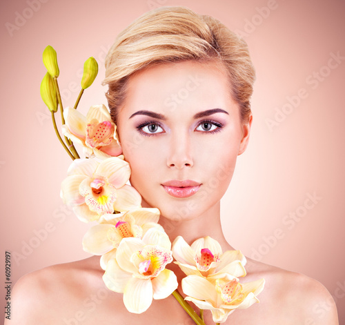 Photo: Woman with health skin and flowers at face. Woman with health skin and flowers at face.