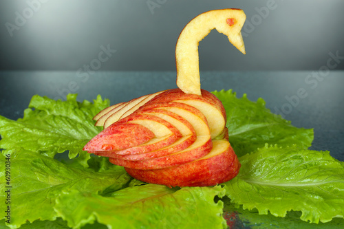 Photo: Carving fruit pattern of swan on grey wet background Carving fruit pattern of swan on grey wet background