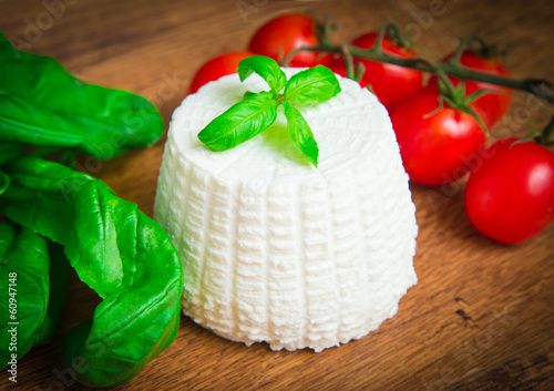 Photo: Fresh ricotta with basil and cherry tomatoes on wooden table Fresh ricotta with basil and cherry tomatoes on wooden table