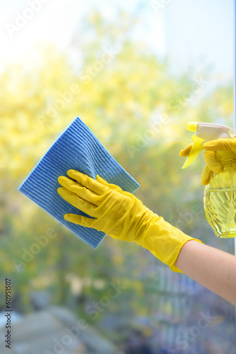 Photo: Hands with spray cleaning the window Hands with spray cleaning the window