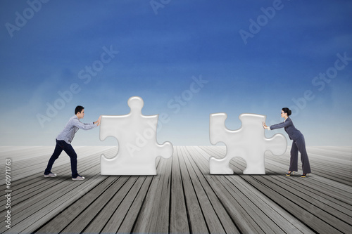 Photo: Two business people put two puzzles Two business people put two puzzles