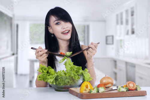 Photo: Young woman making salad Young woman making salad