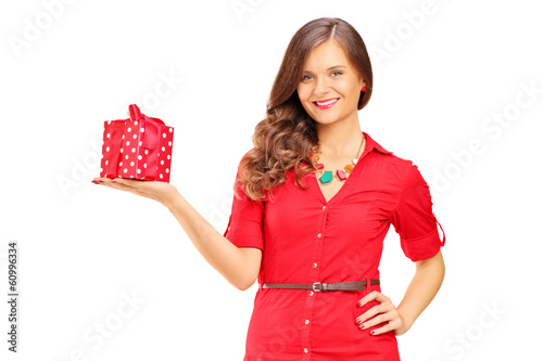 Photo: Attractive smiling woman in red dress holding a gift Attractive smiling woman in red dress holding a gift
