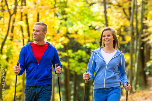 Photo: Nordic walking - active people working out outdoor Nordic walking - active people working out outdoor