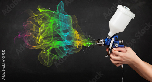 Photo: Painter working with airbrush and paints colorful paint Painter working with airbrush and paints colorful paint