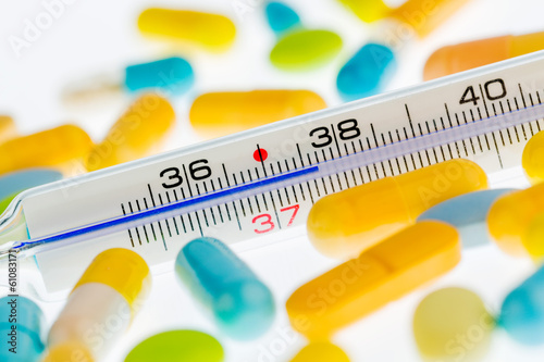 Photo: clinical thermometer and pills clinical thermometer and pills