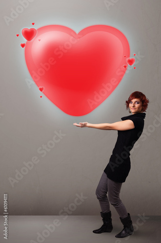 Photo: Young lady holding lovely 3d red heart Young lady holding lovely 3d red heart