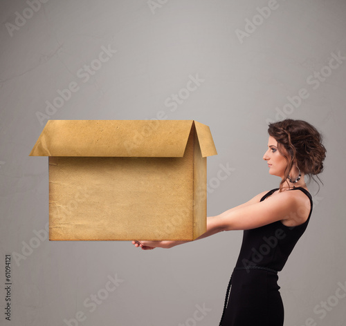 Photo: Young woman holding an empty cardboard box Young woman holding an empty cardboard box
