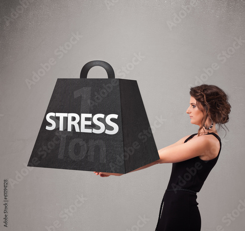 Photo: Young woman holding one ton of stress weight Young woman holding one ton of stress weight