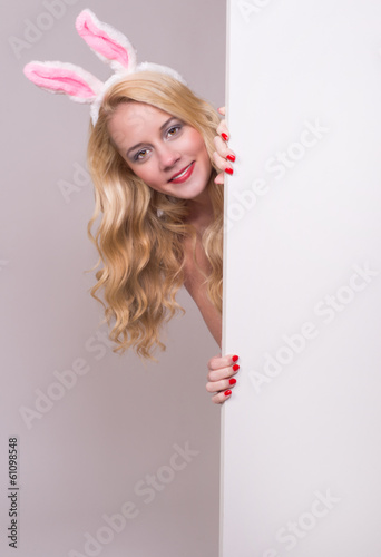 Photo: Bunny girl with blank banner on gray background. Bunny girl with blank banner on gray background.