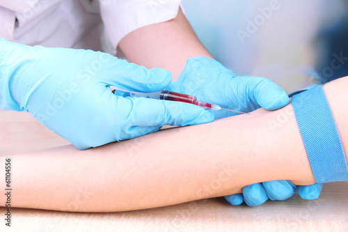 Photo: Nurse taking a blood sample, close up Nurse taking a blood sample, close up