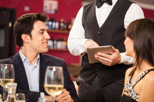 Photo: Waiter using a digital tablet Waiter using a digital tablet